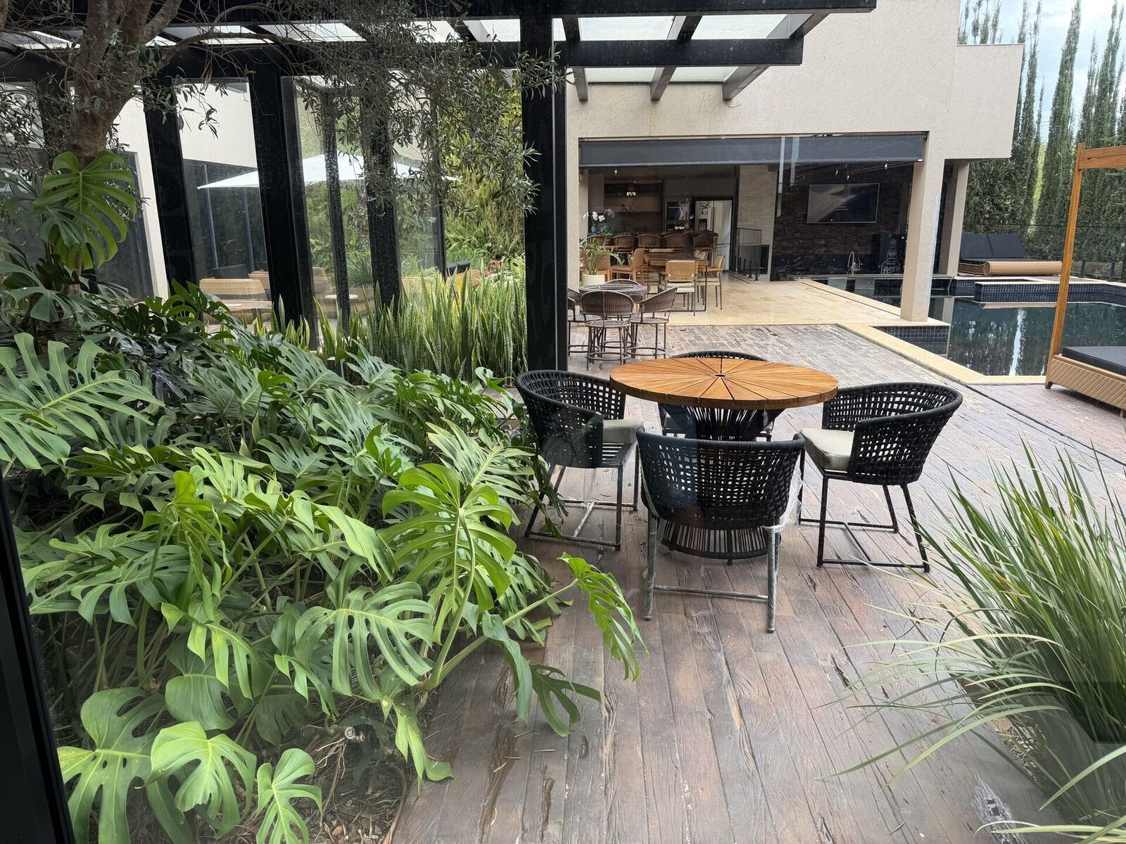 Ambiente externo com poltronas Grupo Pinheiro em deck de madeira